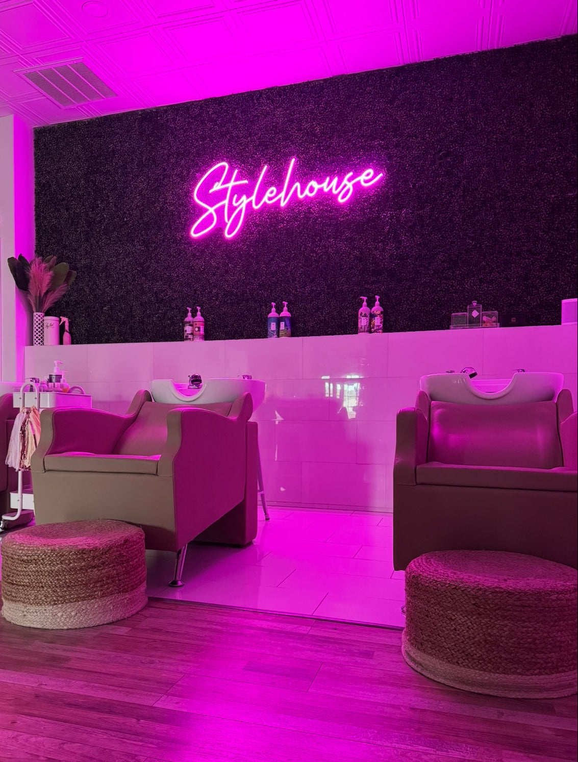 Interior of a salon with pink neon sign and modern furniture